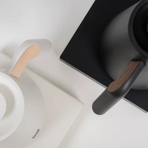 Weißer und schwarzer elektrischer Wasserkocher mit Holzdetails am Griff, präziser Durchfluss für Barista-Brühungen, alles rund um Kaffee.