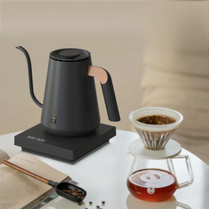 Schwarzer elektrischer Wasserkocher mit Holzdetail am Griff und schmalem Ausguss für Barista- und Brühkaffee-Zubehör, alles rund um Kaffee.